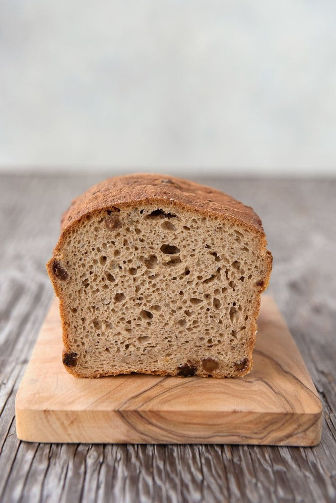 cut face loaf gluten free cinnamon raisin bread on wood cutting board