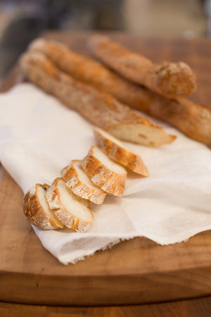 
                  
                    Load image into Gallery viewer, gluten free baguette slices on white cloth on wood cutting board
                  
                