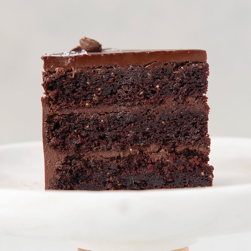 gluten free Vegan Ganache Cake slice on cake stand, dairy-free egg-free