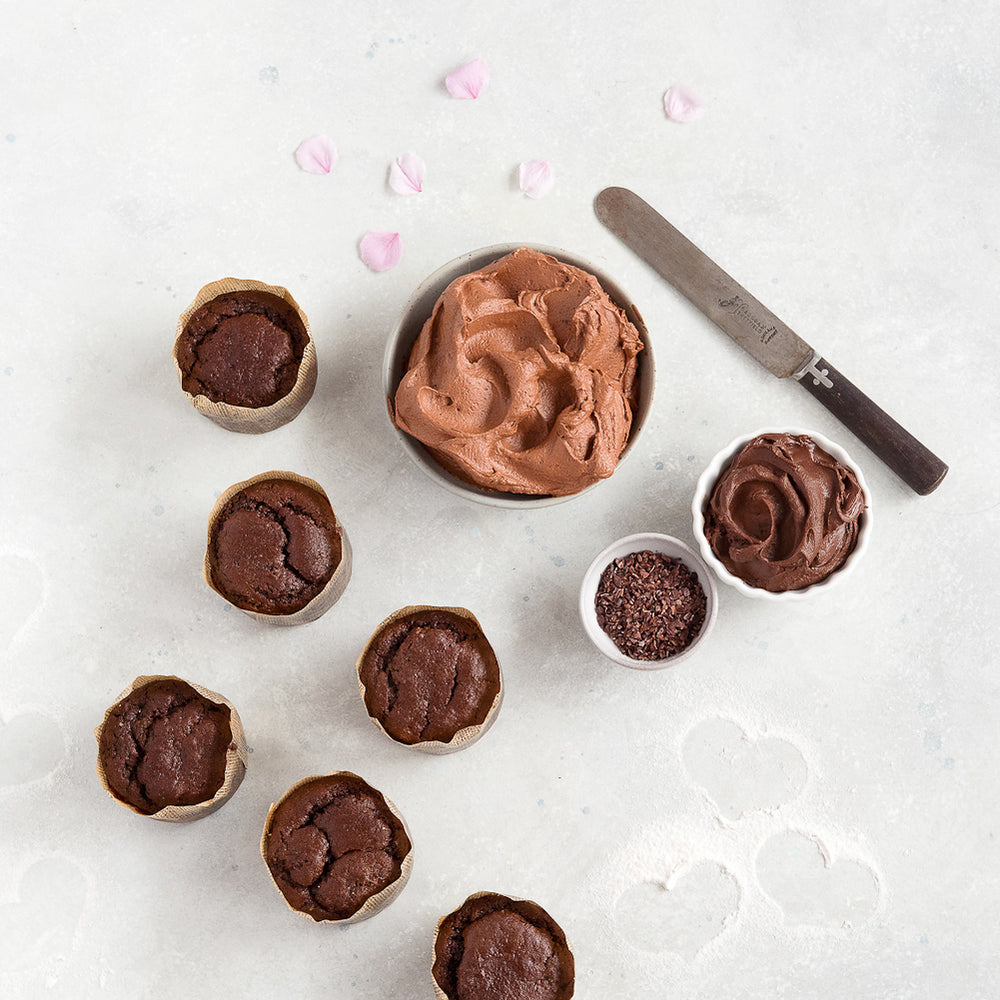 
                      
                        top view 6 gluten free plain chocolate cupcakes shown with bowl chocolate frosting and small bowl ganache
                      
                    
