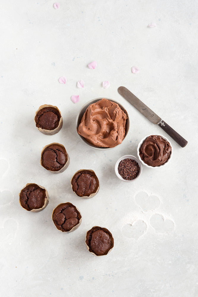 top view 6 gluten free plain chocolate cupcakes shown with bowl chocolate frosting and small bowl ganache