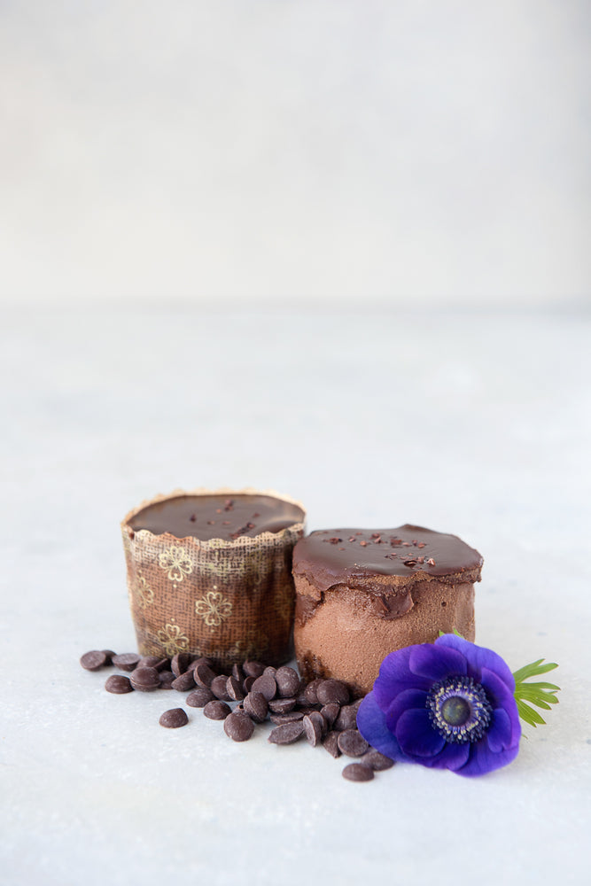 
                  
                    Load image into Gallery viewer, 2 gluten free chocolate mini cheesecakes one in panettone wrapper one unwrapped, shown with chocolate chips &amp;amp; flower
                  
                