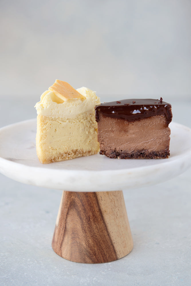 2 halves cut face view mini gluten free cheesecakes on a cake stand, double chocolate and orange creamsicle