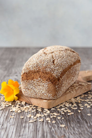 
                  
                    Load image into Gallery viewer, whole loaf gluten free Oat Bread on board shown with oats and flower
                  
                