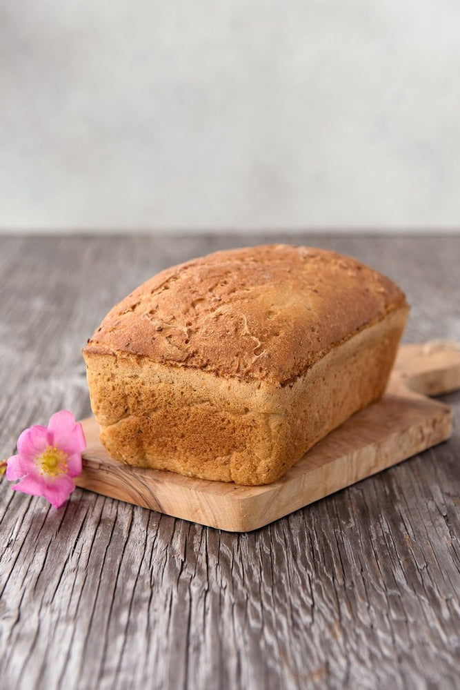whole loaf gluten free Vega Bread on board with flower