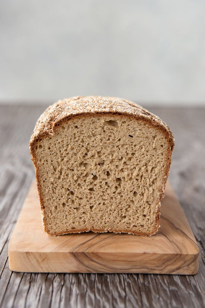 cut face view gluten free Oat Bread on wood board, egg-free