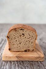 cut face loaf gluten free cinnamon raisin bread on wood cutting board