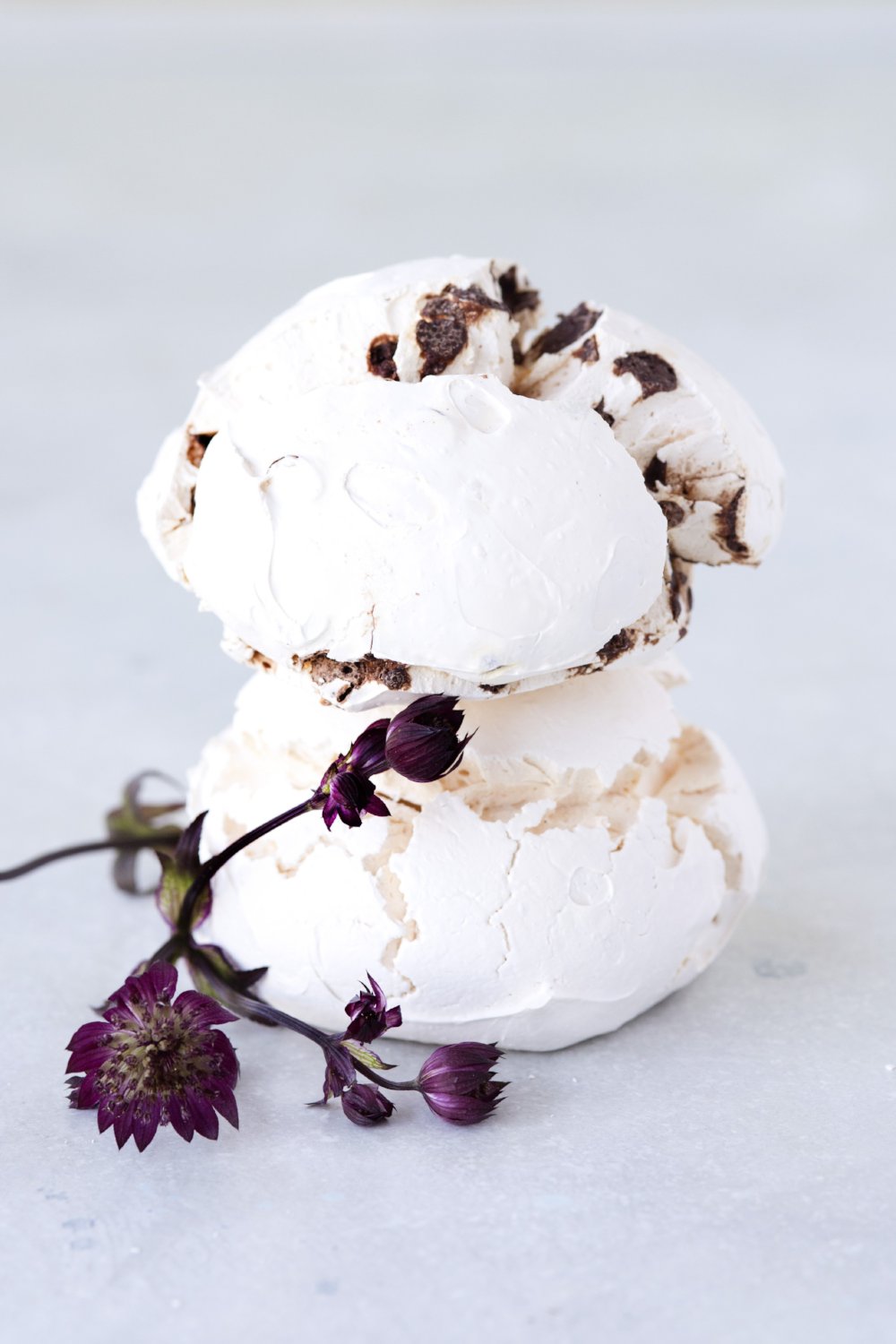stack 2 large chocolate chip meringues shown with purple flowers