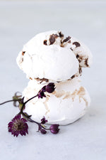 stack 2 large chocolate chip meringues shown with purple flowers